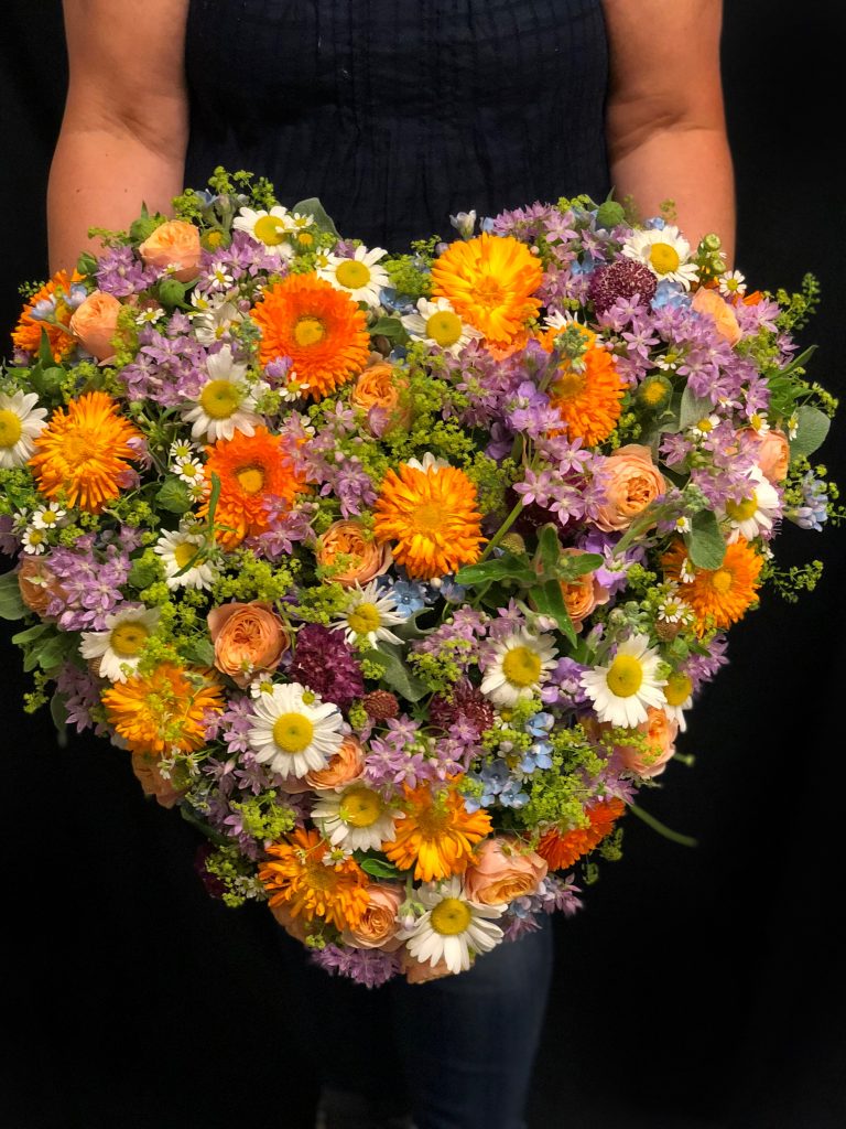 Blommor bundet till hjärta i olika färger