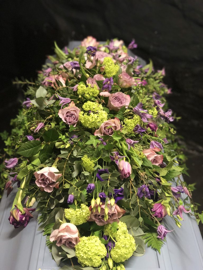 Blommor och gröna blad på kista