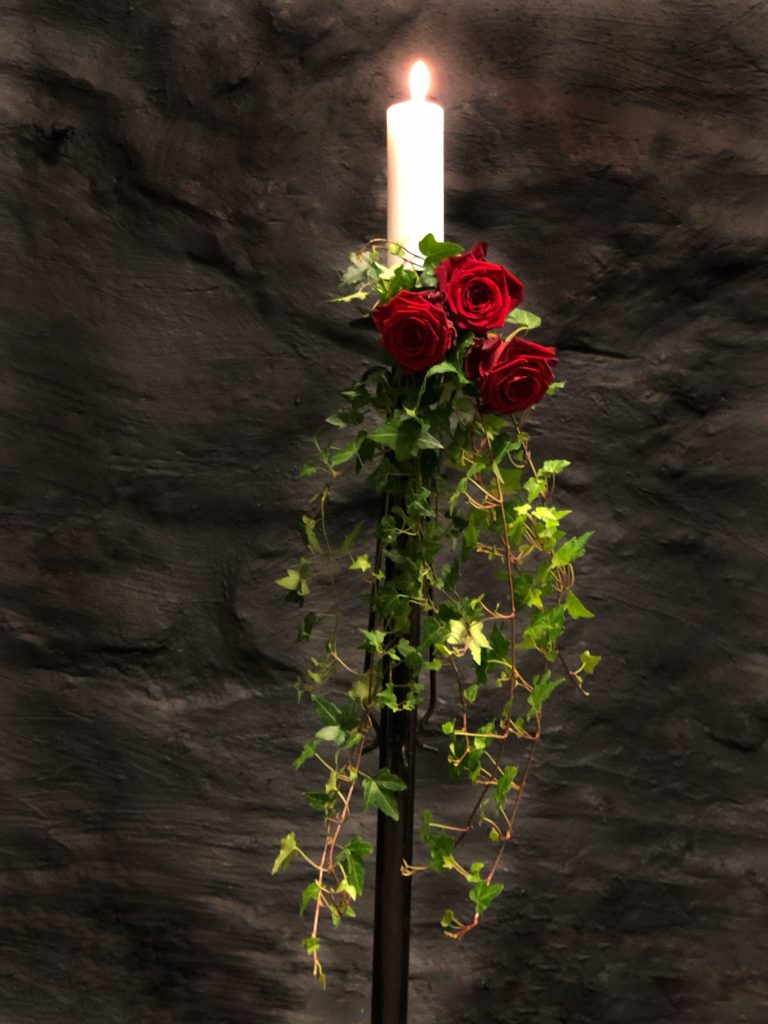 Ljusdekoration med röda rosor och tänt ljus
