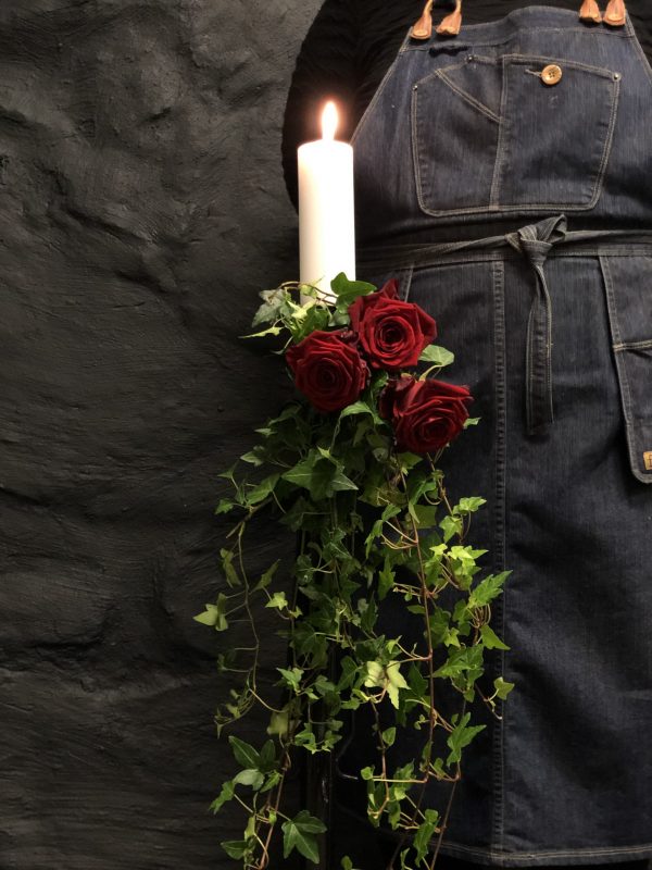 Ljusdekoration med röda rosor och tänt ljus