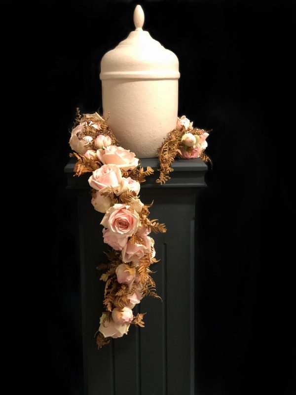 Vit urna med rosa girlang