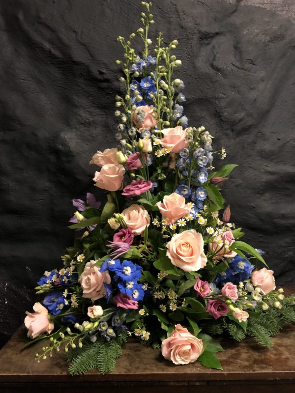 En hög dekoration med blommor i olika färger
