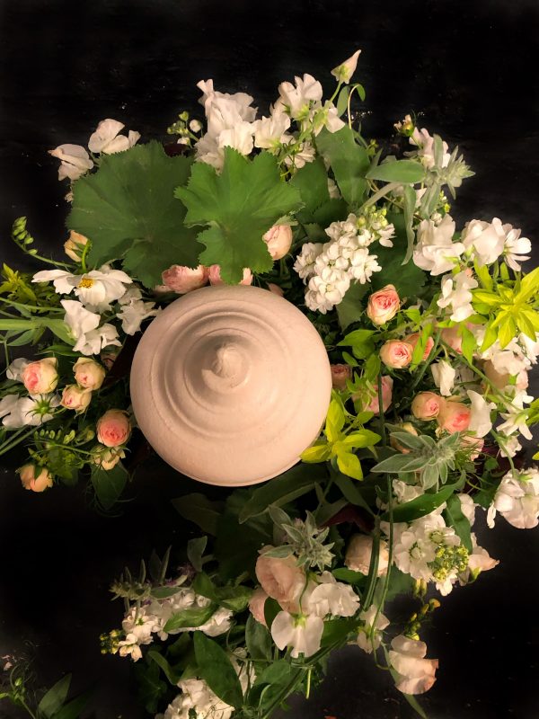Ljus urna med blommor i gröna och ljusa färger