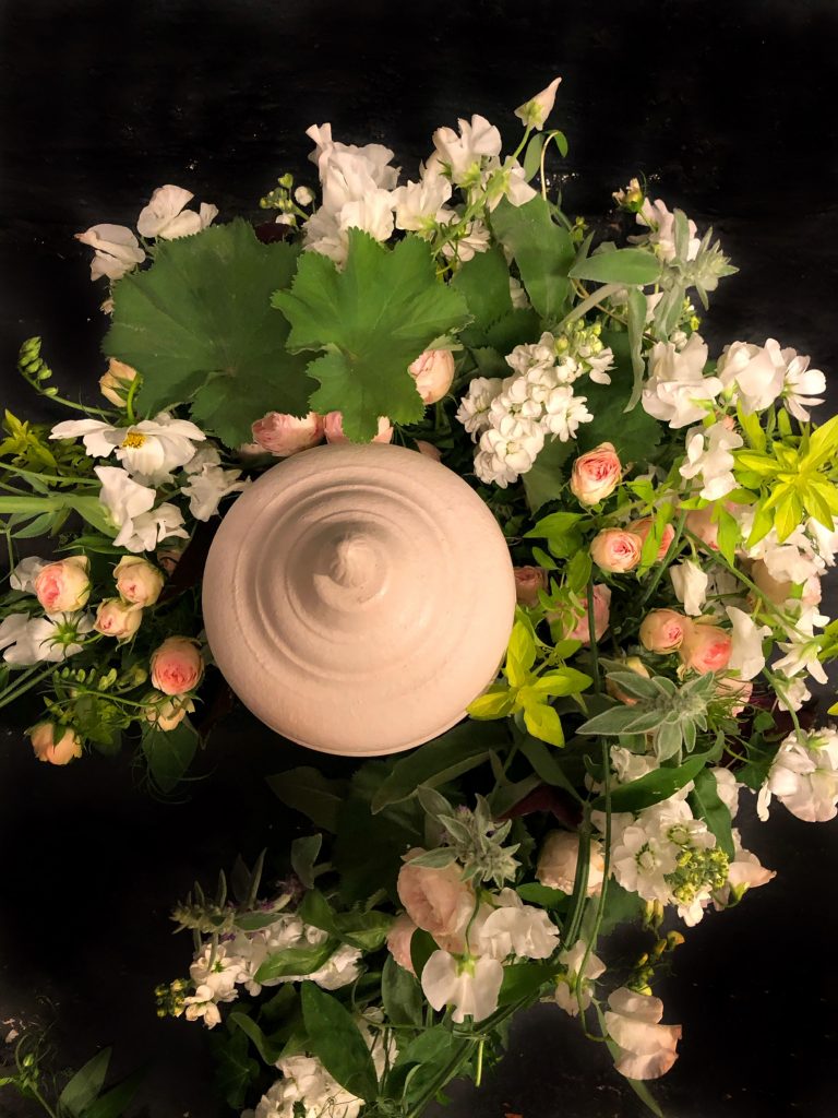 Ljus urna med blommor i gröna och ljusa färger