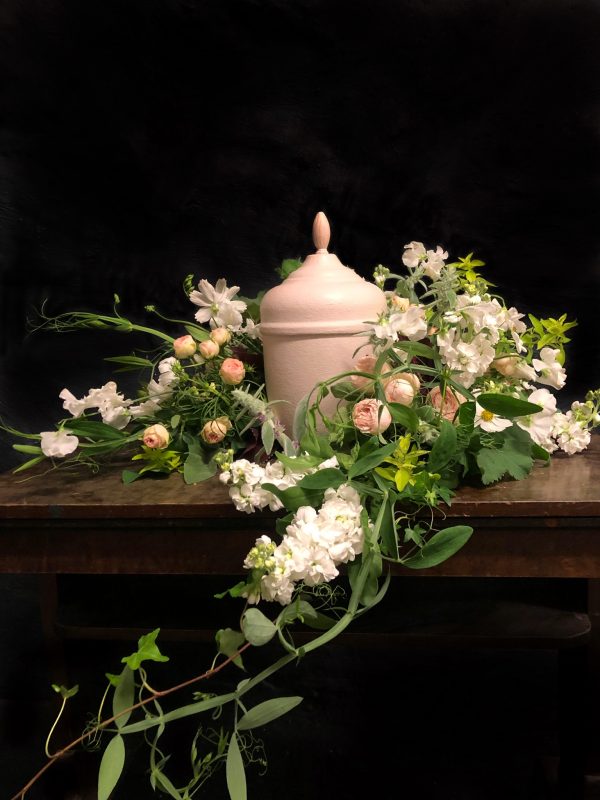 Ljus urna med blommor i gröna och ljusa färger