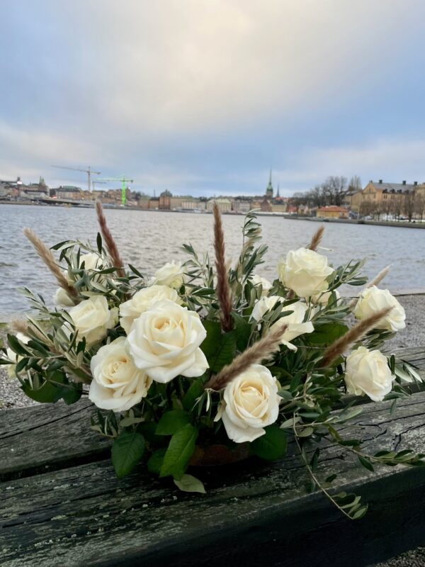 Vita blommor med gröna blad på kaj